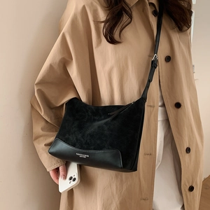 Close-up of black retro crossbody bag with matte leather stitching and fashion logo