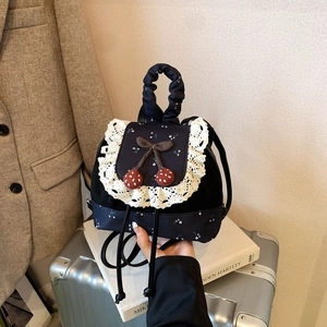 Détail du mini sac à dos floral vintage avec dentelle et décoration cerise nœud
