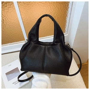 Détail du sac seau en cuir grainé noir montrant la texture souple et la poignée