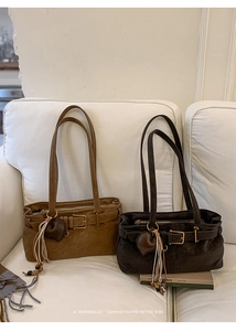 Retro camel and brown baguette bags with heart charms on a white soft sofa