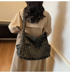 Classic leopard print canvas crossbody bag shown on a model in a long beige trench coat