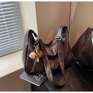 Detail of dark brown tote bag showing smooth PU leather texture and contrast stitching