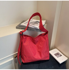 Detail of red checkered oxford fabric texture and adjustable strap on large tote bag