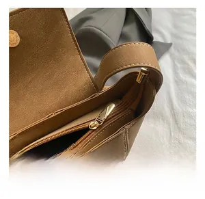 Dettaglio interno della borsa in pelle marrone con cerniera dorata e chiusura magnetica