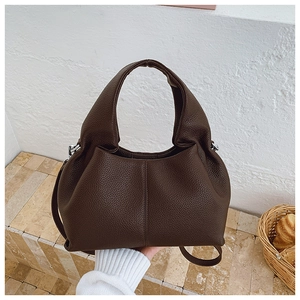 Détail du sac en cuir marron foncé avec grain litchi, boucles en argent et bandoulière