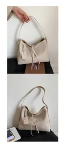 Détail du sac hobo tissé beige montrant la texture et la bandoulière à nœud tendance