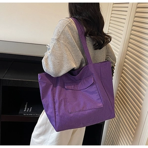 Detail of purple plaid canvas tote bag with large front pocket and long shoulder straps