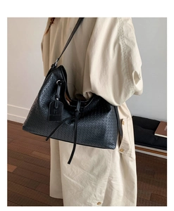 Détail du sac hobo noir tressé avec bandoulière réglable et étiquette déco pour le quotidien