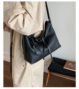 Détail de la texture tissée noire et de l'étiquette sur le grand sac cabas fourre-tout