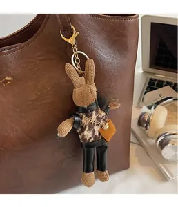Close-up of a creative knitted bunny charm hanging on a brown leather tote bag