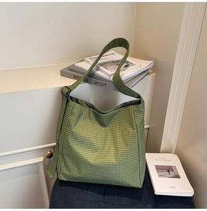 Detail of green and white plaid oxford tote bag with adjustable shoulder strap and metal buckle