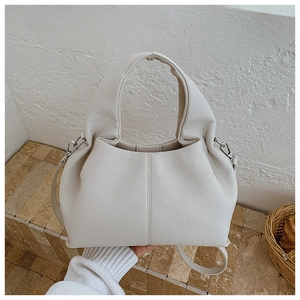 Détail du sac seau en cuir grainé beige avec boucle argentée et bandoulière amovible