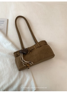 Detail of vintage brown suede shoulder bag with heart pendant and metallic buckle accents