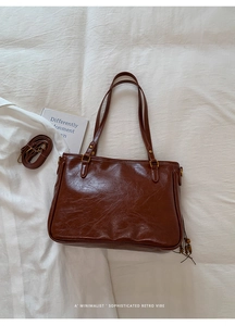 Detail of retro brown leather tote with tassel decoration and detachable long strap