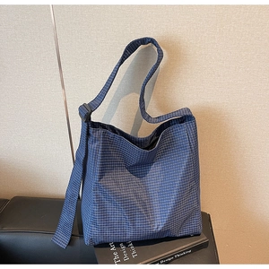 Detail of adjustable black strap and blue plaid oxford fabric on large tote bag