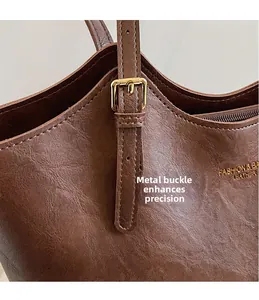Detail of premium brown faux leather tote with high-quality golden metal buckle and stitching