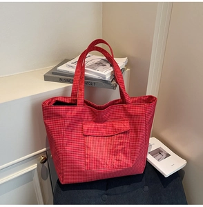 Detail of red plaid canvas tote bag with front pocket in minimalist style