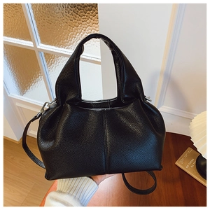 Détails du cuir noir à grain de litchi sur un sac seau au design moderne et chic