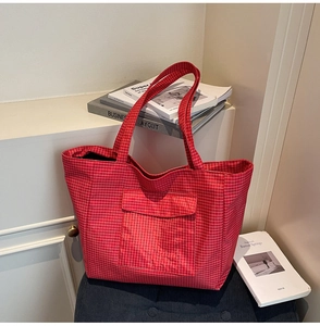 Detail of red checkered tote bag with front pocket on stool in minimalist home setting