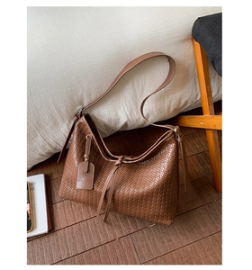 Détail de la texture tressée en similicuir marron sur ce sac cabas chic pour femme