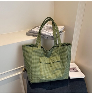Detail of green checkered canvas tote bag with functional front flap pocket