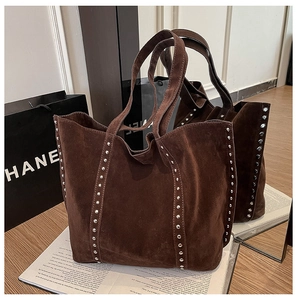 Détail macro du sac cabas en daim marron foncé avec rivets argentés et bandoulières