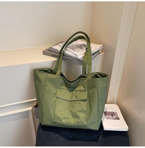 Detail of green plaid nylon shoulder bag with functional front flap pocket and sturdy straps