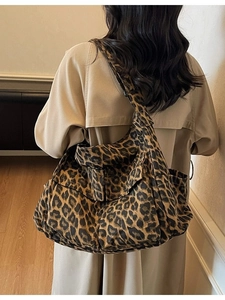 Classic leopard print canvas tote bag with adjustable shoulder strap worn by a model