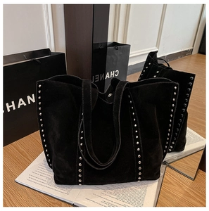 Détail de sac cabas en daim noir avec des rivets argentés verticaux élégants