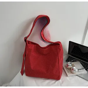 Macro detail of red and white plaid oxford fabric tote with adjustable wide shoulder strap