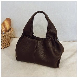 Gros plan détaillé d'un sac à main en cuir marron foncé avec une silhouette nuage vintage