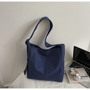 Detailed view of blue plaid canvas tote bag with wide strap and adjustable buckle