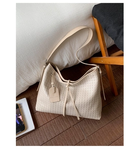 Gros plan détaillé sur le tissage crème et l'étiquette décorative d'un sac hobo chic