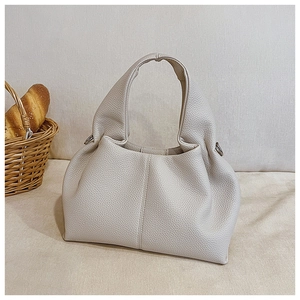 Vue détaillée du sac seau blanc crème avec texture litchi et anneaux en métal