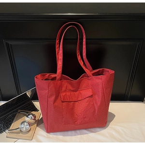 Detail of red checkered canvas tote bag with reinforced straps and front flap pocket