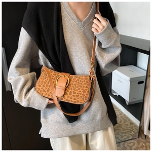 Detail shot of leopard print shoulder bag featuring a large decorative metal ring buckle