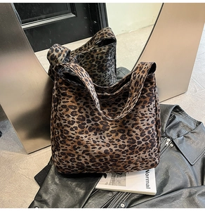 Gros plan du sac fourre-tout léopard posé sur une veste en cuir noir chic