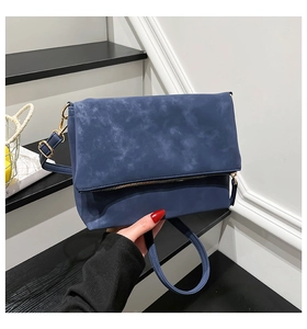 Detail of the textured navy blue synthetic leather with vintage marble effect on the bag