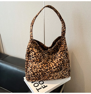Détail d'un sac hobo à motif léopard avec bandoulière large sur un support déco