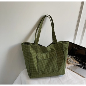 Green checkered large tote bag with front pocket shown with a laptop for work or school