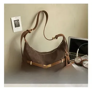 Detail of deep brown hobo bag with gold hardware and elephant leather charm