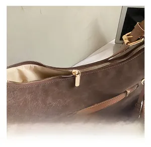 Close-up of vintage brown leather tote with premium gold zipper and detailed texture