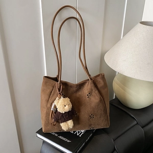 Retro brown suede tote bag with floral cutouts and cute bear charm for daily commute