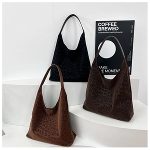 Three large leopard print tote bags in minimalist suede displayed on white steps