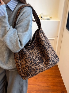 Sac cabas classique à motif léopard avec large bandoulière porté par un mannequin chic