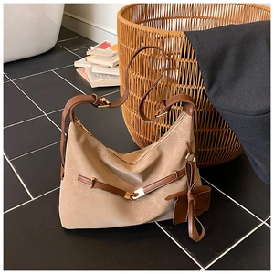 Detail of retro khaki tote bag with dark brown leather straps and vintage metallic hardware