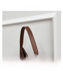 Detailed close-up of smooth brown leather shoulder straps on a leopard print tote bag