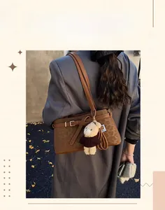 Detail of vintage leopard bucket bag with plush bear charm and textured matte finish