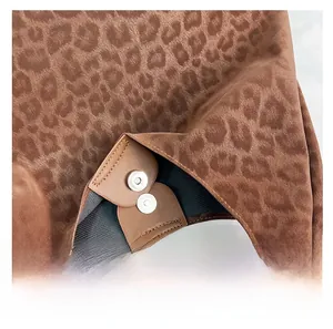 Close-up of silver magnetic clasp on leopard print tote bag with soft suede-like texture