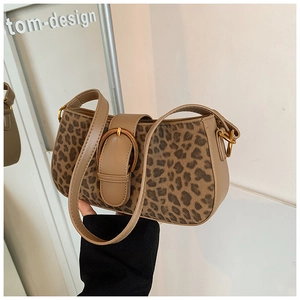 Detailed close-up of leopard print shoulder bag with golden horseshoe metal buckle